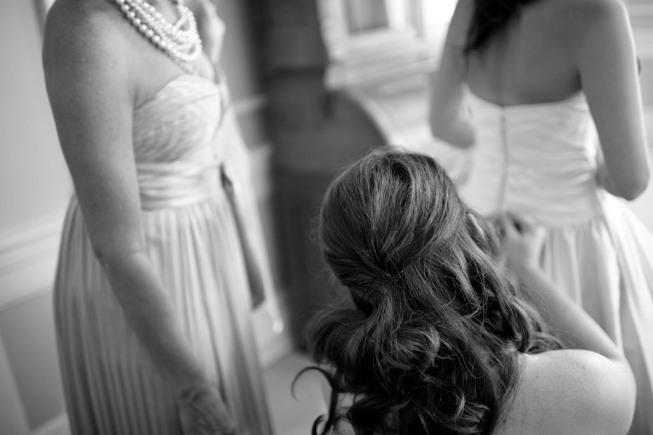 Maid of honor helping bride get dressed