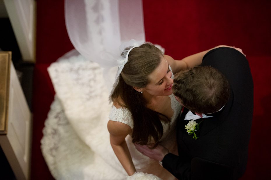 Bride and groom kissing at the end of the aisle