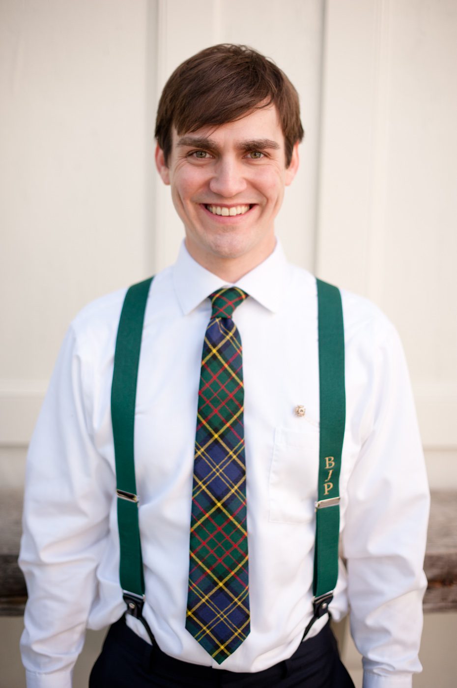Groom in monogrammed suspenders